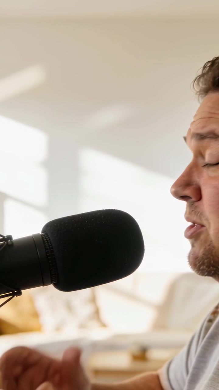 Video verticale: Inizio della registrazione, podcaster maschio adulto che parla in un microfono con spugna a casa per registrare.