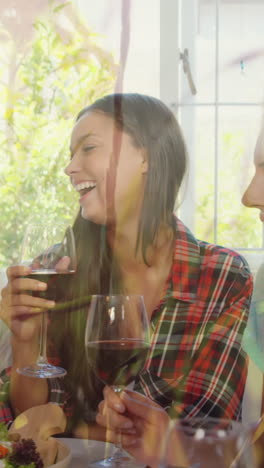 animación de hierba sobre amigos caucásicos femeninos y masculinos bebiendo vino y hablando en casa