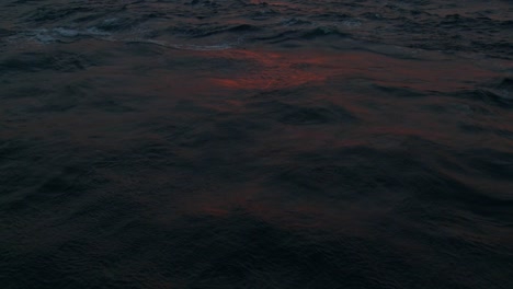 red sunset light reflects off ocean waves