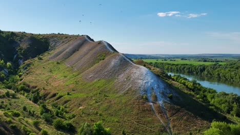 scenic hillside view with river and paragliders