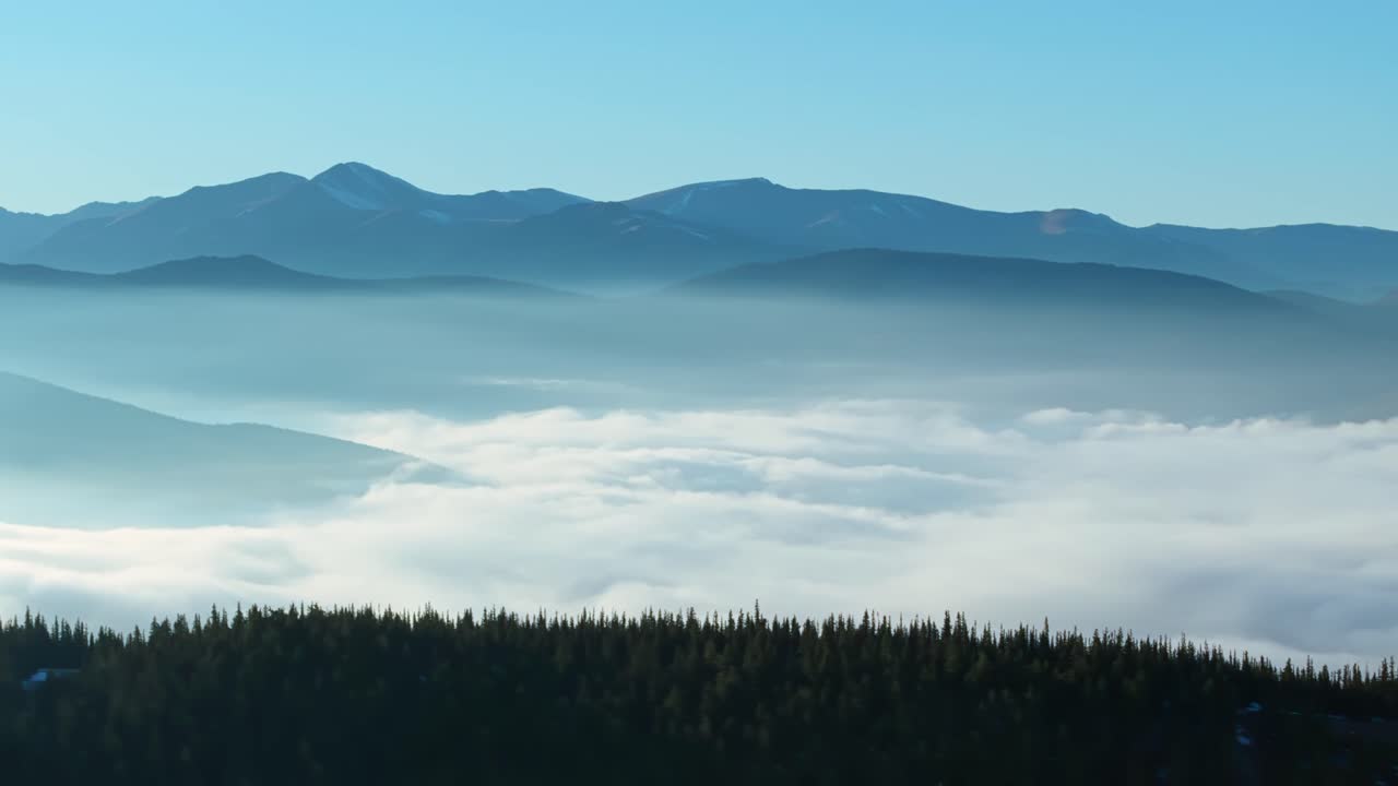 Drone aerial reveals sweeping Colorado mountain landscape at Juniper Pass emerging from morning cloud cover