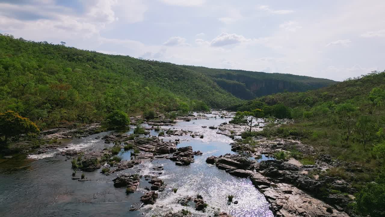 vista aérea de una cascada que cae en cascada por una ladera rocosa, rodeada de vegetación verde en el parque nacional de chapada dos veadeiros, brasil, creando un paisaje natural impresionante
