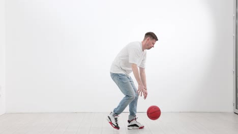man dribbling a basketball indoors