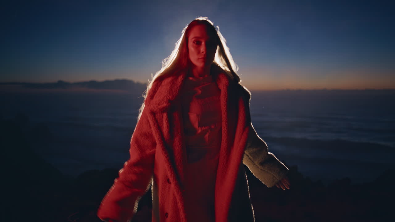 modelo de moda posando en la playa al atardecer con abrigo de piel. mujer modelando en el baile.