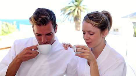 happy couple having coffee together in bathrobes