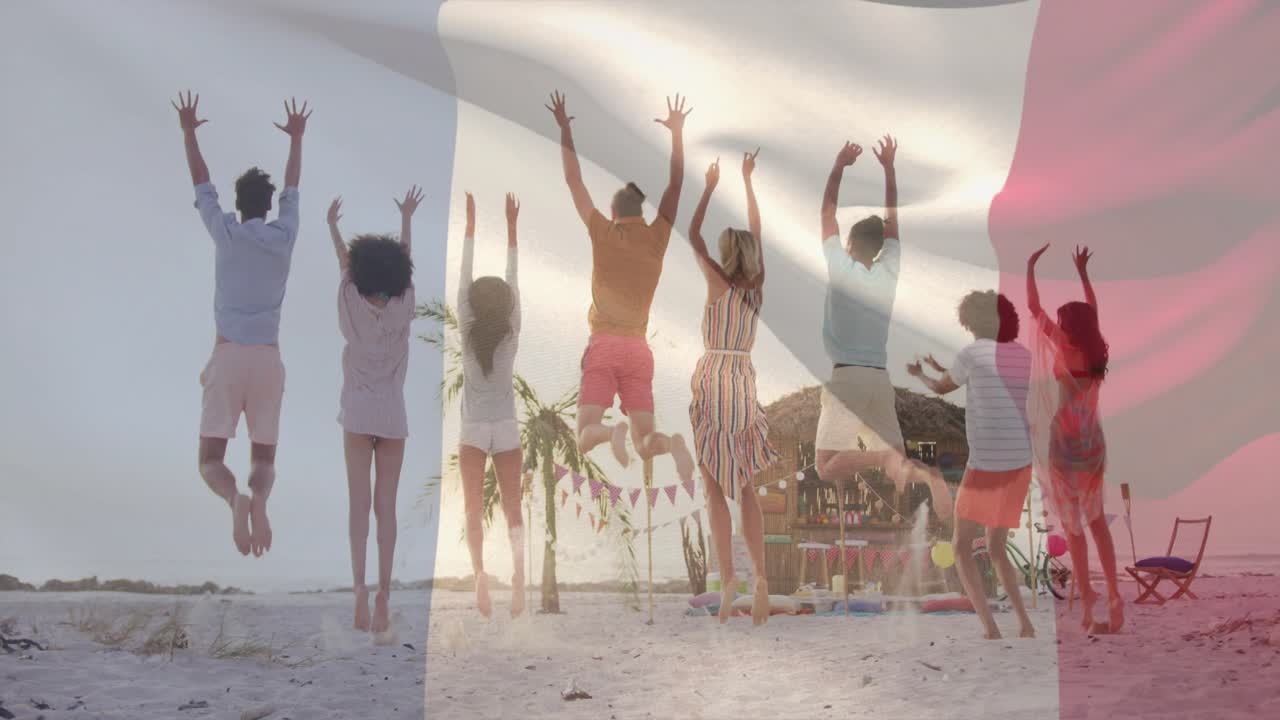 여행을 위해 해변에서 팔짱을 끼고 점프하는 8명의 성인, 그룹 위로 삼색 깃발이 흩날리고 있어요