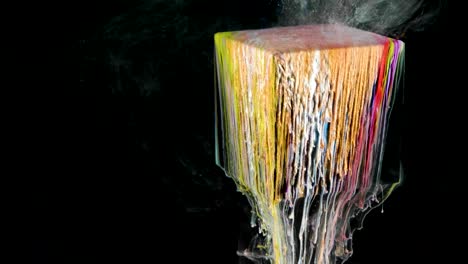 multicolored ink paint slowly flows from the cube underwater