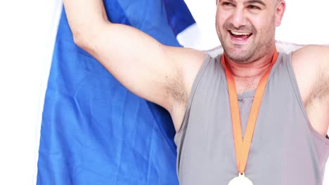 Happy-athlete-with-medal-holding-flag