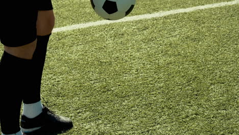 Cerca-De-Un-Jugador-De-Fútbol-Irreconocible-Entrenando-Trucos-De-Estilo-Libre-Con-La-Pelota-O-Un-Campo-De-Fútbol-Callejero-En-Un-Día-Soleado