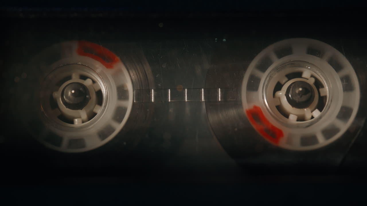 Audio cassette spinning reels loaded in vintage deck closeup. Macro classic tape