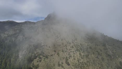 Moving-to-left-above-mountain-in-a-foggy-day-with-view-of-Pico-del-Aguila-in-Mexico-City