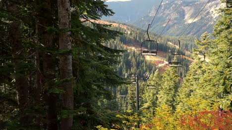 an empty chair lift at a ski resort moving up and down the mountain during an autumn day