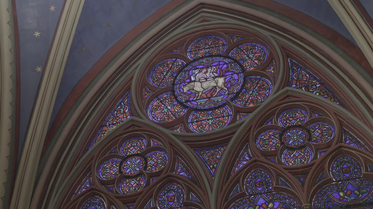 Stained glass window in Notre-Dame de Paris with intricate design and vibrant colors