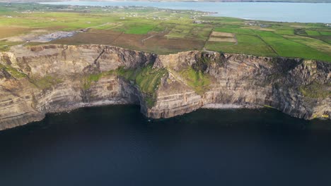 Drone-shot-flying-backwards-away-from-the-Cliffs-of-Moher-at-sunset