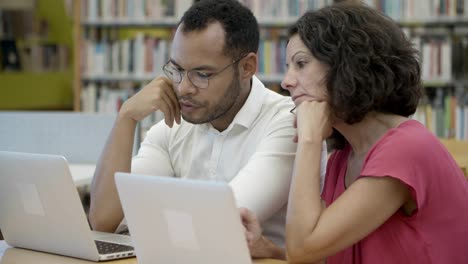 estudiantes maduros cansados mirando portátiles