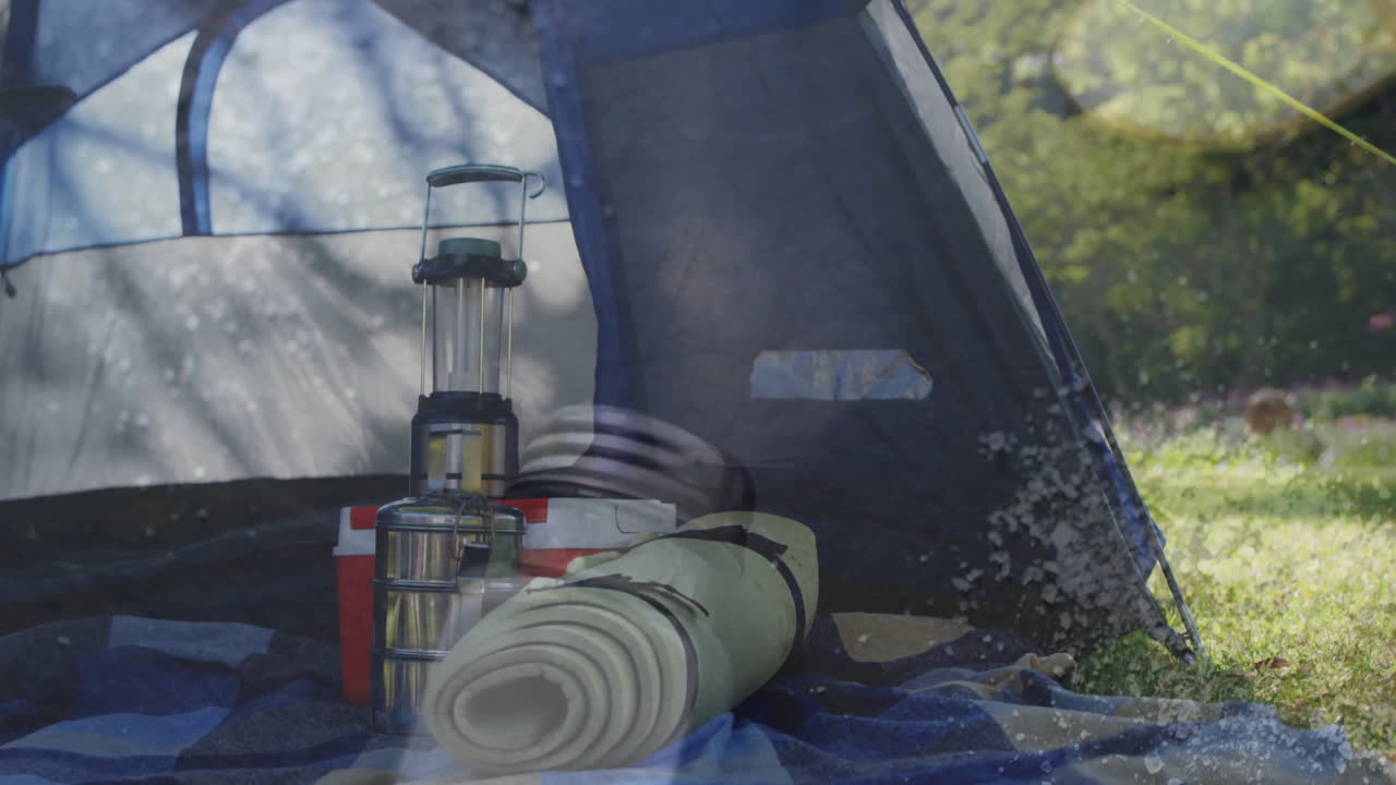 Camping gear inside tent with lantern and sleeping bag in nature setting