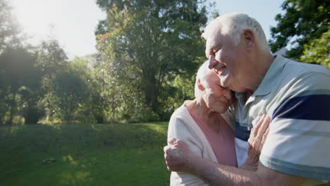 una feliz pareja caucásica se abraza en un jardín soleado, cámara lenta, espacio de copia