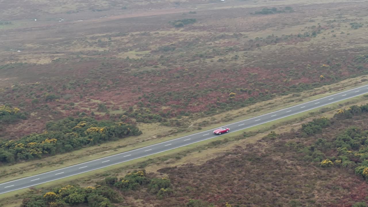 toma aérea de drones rastreando auto en carretera abierta