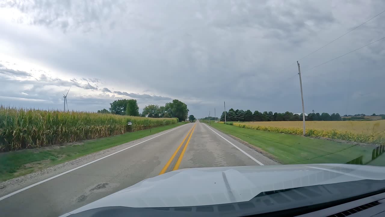 - 거의 수확 준비가 된 작물이 있는 농장과 을 지나 시골 도로를 운전하는 pov