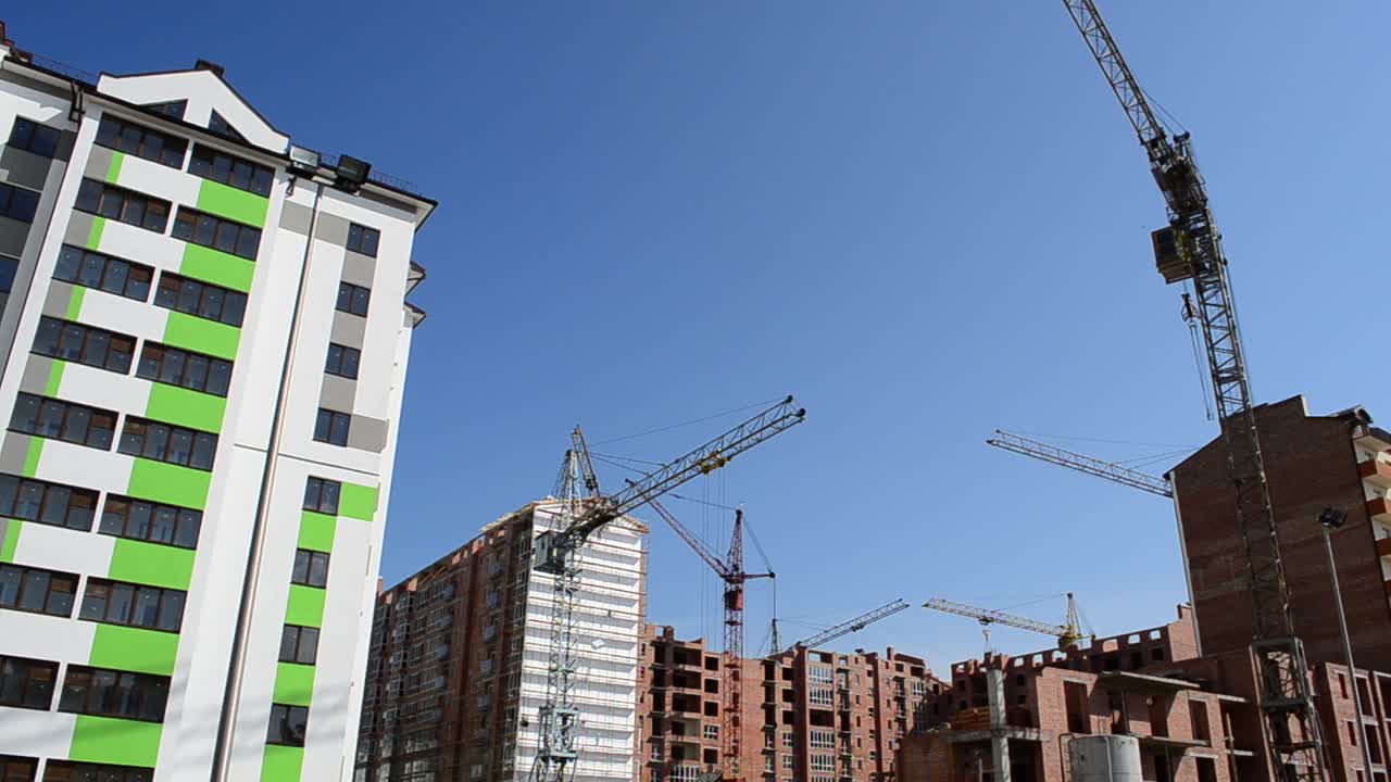 Gru edili sopra le case. Costruzione di edifici residenziali