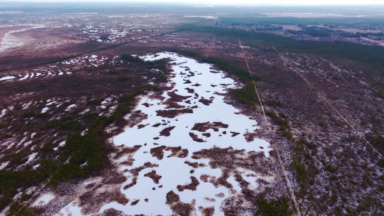 Aerial view of icy Cena bog ponds surrounded by calm northern wilderness