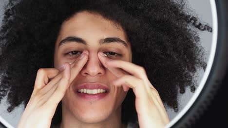 hombre de cuidado de la piel aplicando crema facial debajo de los ojos