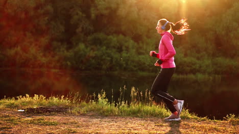 a morning jog in the park near the pond in the sunny rays of dawn, the girl is preparing to mariano and lead a healthy lifestyle