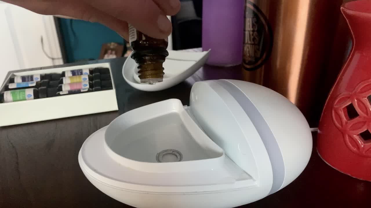 가정용 향수 디퓨저에 필수 아로마테라피 오일을 추가하는 젊은 남자의 손