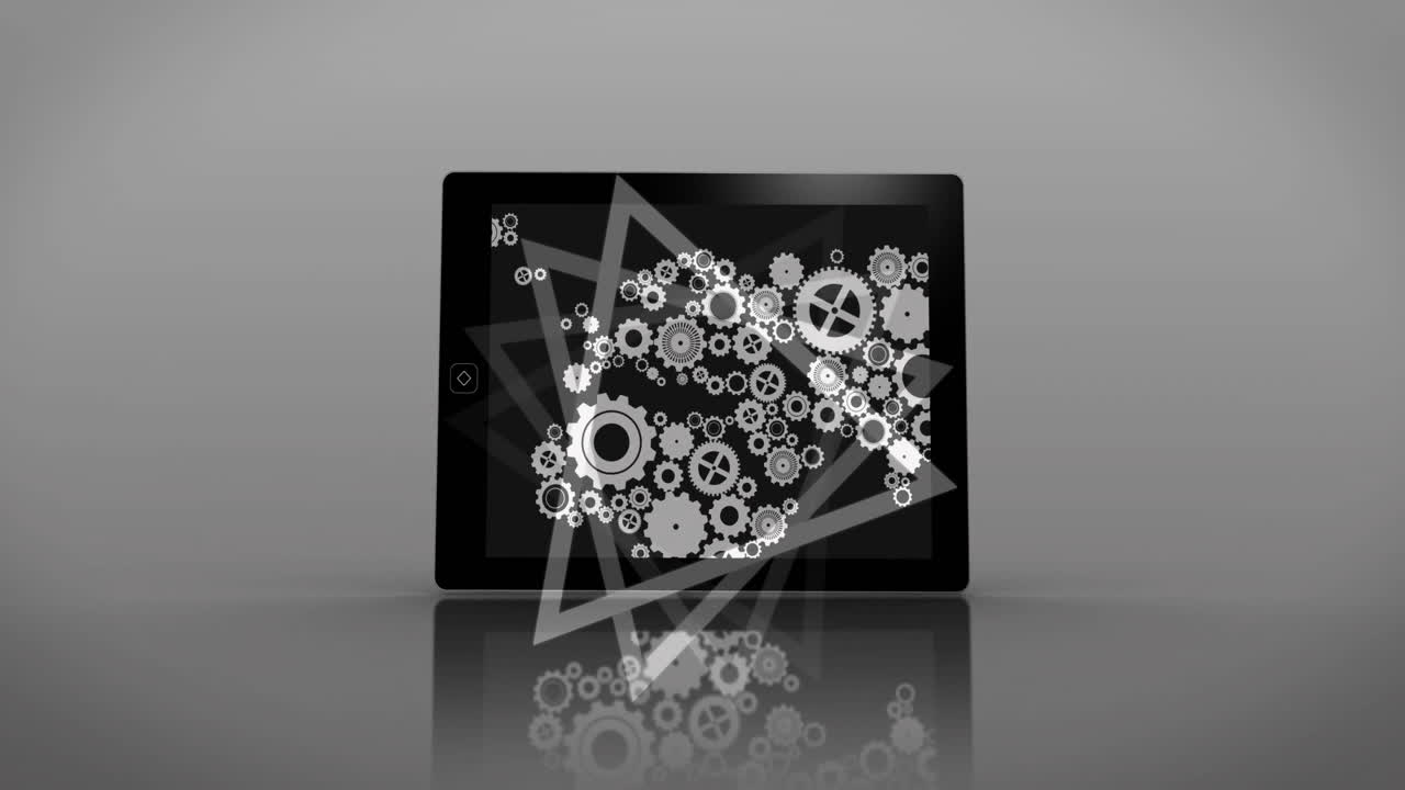 Gears and triangle animation over tablet screen on reflective surface