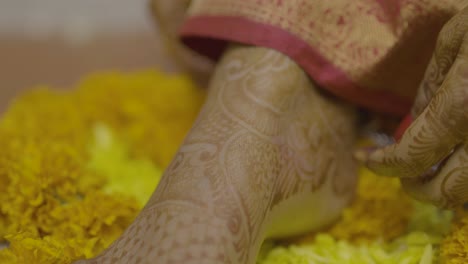 indian wedding session anklet fitting on mehndi applied feet