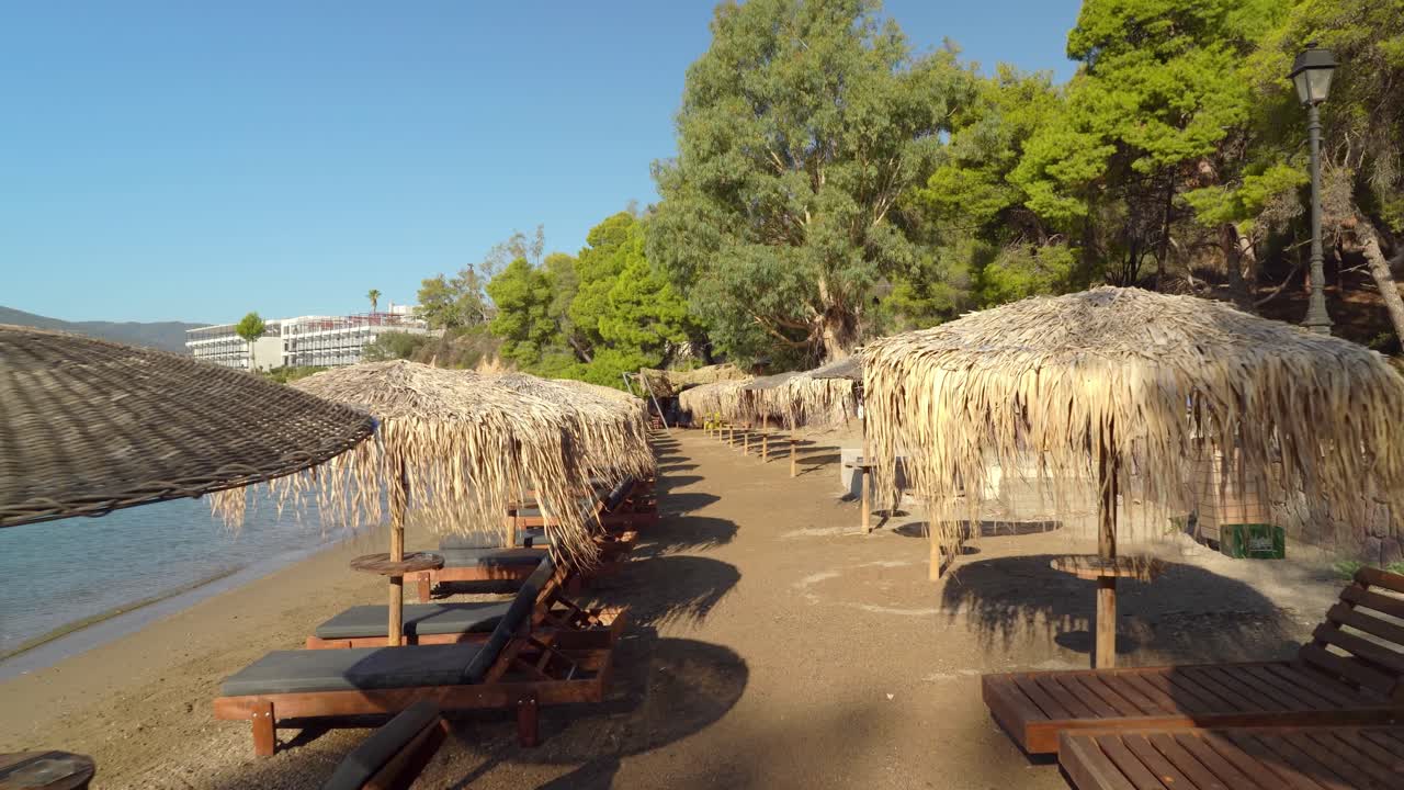 paralia mikro neorio의 말린 잔디 파라솔이 있는 선베드