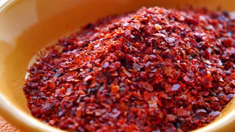 close up of red pepper flakes in a bowl