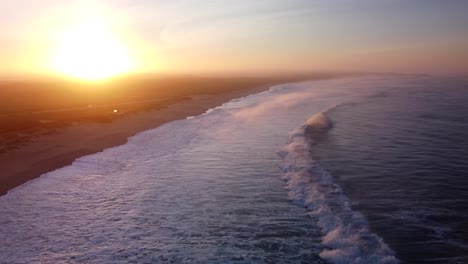 Vista-Aérea-De-Las-Olas-Que-Llegan-A-La-Costa-De-La-Playa-De-Supertubos-Durante-La-Puesta-De-Sol-Dorada-En-Portugal