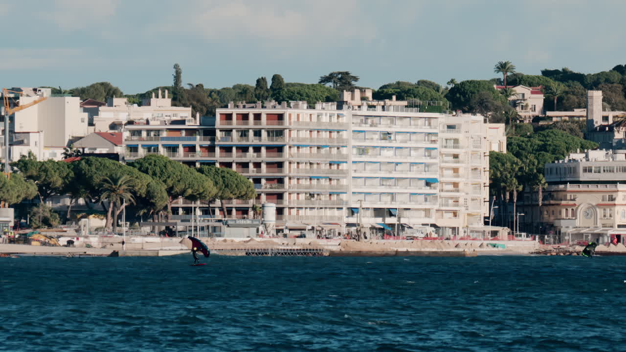 Distant view of a men practicing wing surfing on the sea in Vallauris, France