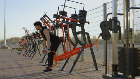 man working out outdoors on exercise machines