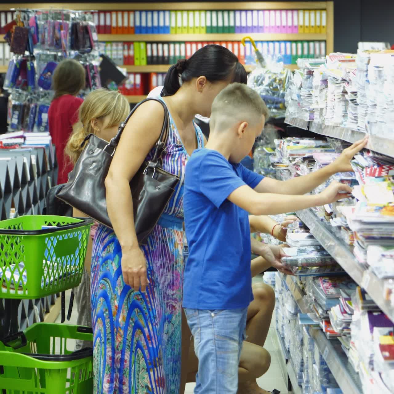 VINNITSA, UKRAINE - AUGUST 20, 2018: Shopping for school. Boy buying different products in stationery shop.