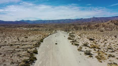 volando sobre un camino de tierra a través de un colorido pero árido paisaje desértico