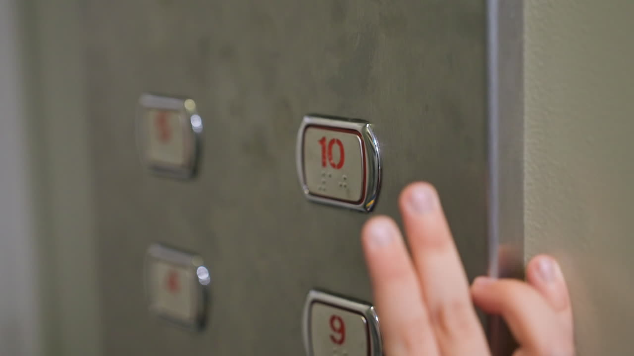 Sons small hand pressing elevator button, closeup of childs fingertip activating illuminated on metal panel, warm lobby lighting, reflective surface, subtle guidance from nearby mom implied, family