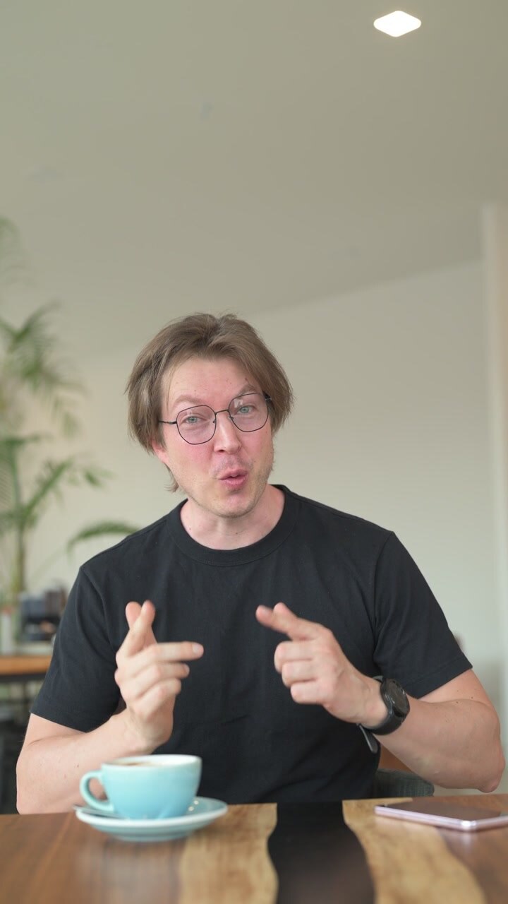 Influencer uomo scandinavo nordeuropeo seduto in un bar o ristorante che fa vlogging e parla alla telecamera