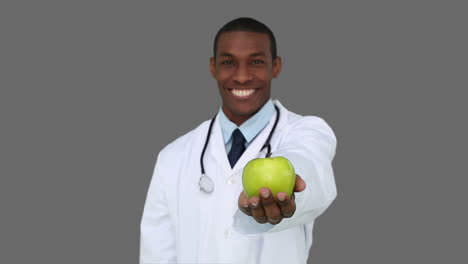 Happy-young-doctor-showing-camera-an-apple