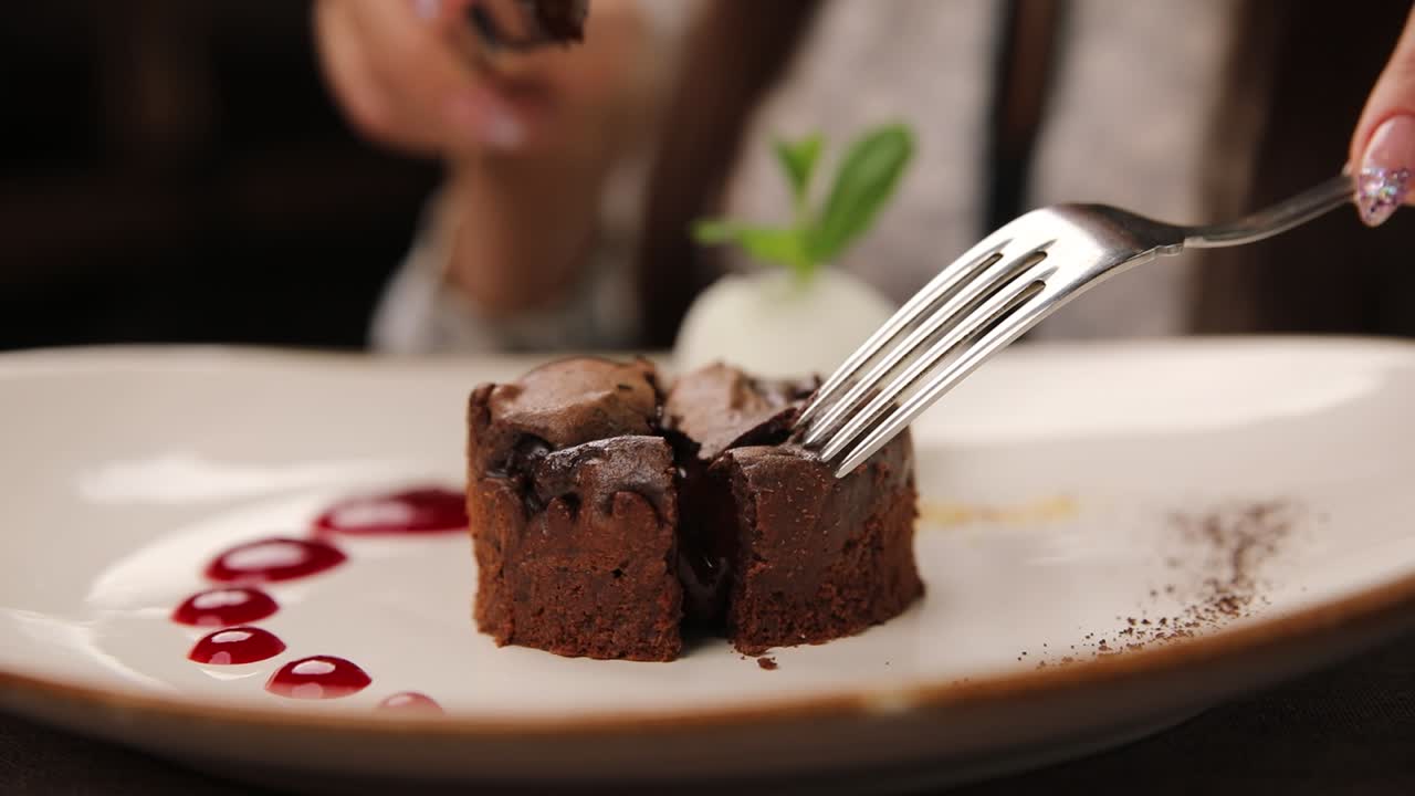 mujer comiendo pastel de chocolate fondant
