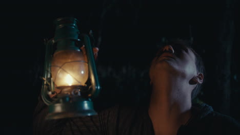 man holding a lantern in the dark