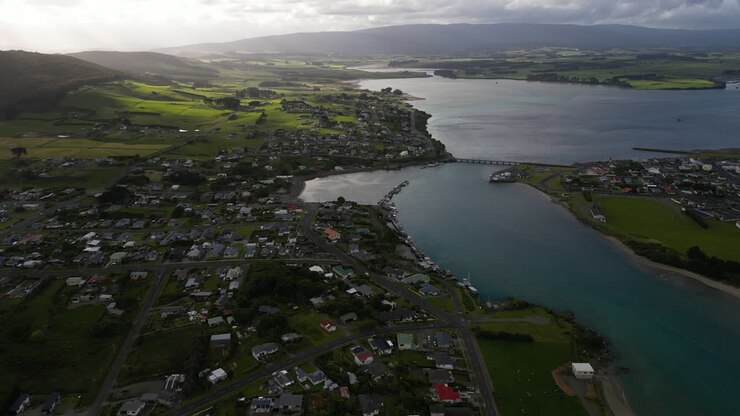 Veduta aerea con drone della città costiera di Riverton, Nuova Zelanda, sotto un cielo nuvoloso.