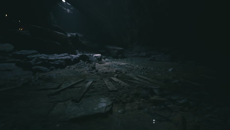 dark cave interior showcasing rocky terrain and scattered debris