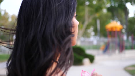 a young hispanic woman hipster wearing vintage fashion clothing in a park playground