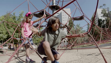 foto larga de un niño y una niña escalando atracciones en un parque de atracciones