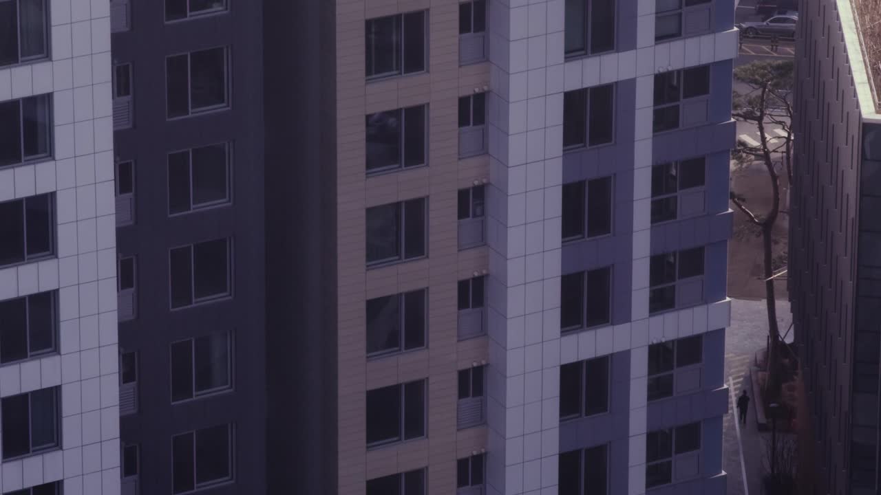 hombre solitario caminando por un bloque de apartamentos en la ciudad asiática