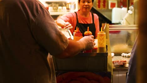 vendor serving food at a bustling street stall