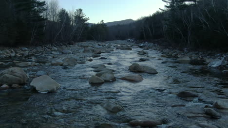 aerial cinematic pan to the right slide the river early morning winter east branch pemigewasset river loon mountain resort new hampshire