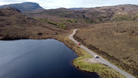 cars driving alongside a scenic loch - scotland